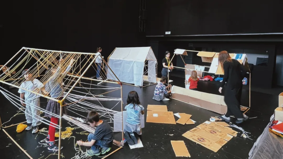 niños construyendo casas con cartón